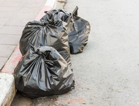 Image of man and van loading household rubbish in a busy Charlton street